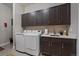 Laundry room with washer, dryer, cabinets, and sink at 5069 Castle Pines S Dr, Castle Rock, CO 80108