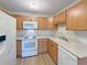 Efficient kitchen with oak cabinets, white appliances, and granite countertops at 13606 E Bates Ave # 304, Aurora, CO 80014