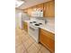 Kitchen with light wood cabinets, white appliances, and speckled countertops at 10243 E Peakview Ave # A103, Englewood, CO 80111