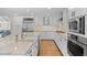 Well-appointed kitchen features white shaker cabinets, stainless steel appliances and hardwood floors at 560 Front Range Rd, Littleton, CO 80120