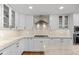 White kitchen with gas range, custom backsplash and ample counter space at 560 Front Range Rd, Littleton, CO 80120