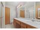 Bathroom with double sinks, shower, and wood cabinets at 1225 Baker St, Longmont, CO 80501