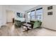 Bright living room with green velvet sofas, wood floor, and large windows at 6233 N Liverpool St, Aurora, CO 80019