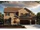 Two-story home with beige stucco siding, brown roof, and three-car garage at 941 Saint Andrews Ln, Louisville, CO 80027