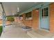 Covered patio with brick walls, a light blue door and outdoor seating at 6661 Harlan St, Arvada, CO 80003