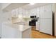 Kitchen features a breakfast bar, white cabinets, and stainless steel appliances at 3460 S Poplar St # 307, Denver, CO 80224