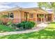 Brick ranch-style home with covered porch and landscaped yard at 1432 Xanthia St, Denver, CO 80220