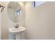 Small bathroom with pedestal sink and round mirror at 10231 E 62Nd Pl, Denver, CO 80238