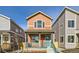 Two-story home with orange siding, teal porch, and landscaped yard at 10231 E 62Nd Pl, Denver, CO 80238