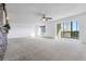 Spacious living room with carpet, sliding glass door to balcony, and ceiling fan at 14152 E Linvale Pl # 605, Aurora, CO 80014