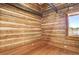 Rustic log cabin wall with wood flooring and a window at 7948 S Turkey Creek Rd, Morrison, CO 80465