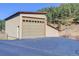 Attached garage with large door and stucco exterior at 7948 S Turkey Creek Rd, Morrison, CO 80465