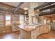 Spacious kitchen with log cabin walls, custom island, and a wood-burning stove at 7948 S Turkey Creek Rd, Morrison, CO 80465