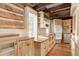 Rustic kitchen with log cabin walls, white appliances, and copper countertops at 7948 S Turkey Creek Rd, Morrison, CO 80465