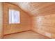 Cozy attic bedroom with wood walls and a window at 7948 S Turkey Creek Rd, Morrison, CO 80465