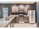 Modern kitchen with dark cabinets, granite countertops, and stainless steel appliances at 7203 Arkansas St, Frederick, CO 80530