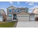 Two-story house with a beige and brown exterior, stone accents, and a three-car garage at 4007 N Reserve Blvd, Aurora, CO 80019