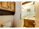 Small bathroom with wood vanity, shower, and built-in shelving at 6584 Kline St, Arvada, CO 80004