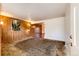 Open living room with wood paneling and carpeted floors at 6584 Kline St, Arvada, CO 80004