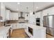 Modern kitchen with white cabinets, herringbone backsplash and island at 42972 Colonial Trl, Elizabeth, CO 80107
