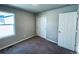 Simple bedroom with carpet, a window, and double doors to closet at 19085 E 66Th Ave, Denver, CO 80249