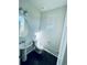 Clean powder room with pedestal sink, toilet, and dark wood flooring at 19085 E 66Th Ave, Denver, CO 80249