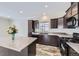 Modern kitchen with dark cabinets, an island, and tile floors at 149 Poplar St, Lochbuie, CO 80603