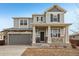 Two-story house with gray siding, stone accents, and a front porch at 320 Mayeda St, Brighton, CO 80601