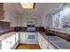White kitchen with updated appliances and wood flooring at 11008 Vrain Ct, Westminster, CO 80031