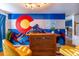 Bar area with Colorado mural and two yellow stools at 11008 Vrain Ct, Westminster, CO 80031