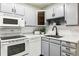Modern kitchen with gray cabinets and white appliances at 9315 E Center Ave # 11A, Denver, CO 80247