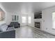 Living room with gray wood-look flooring, fireplace, and large windows at 493 N 48Th Ave, Brighton, CO 80601