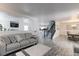 Open-concept living room with gray couches, wood-look flooring, and a view of the dining area at 493 N 48Th Ave, Brighton, CO 80601