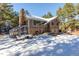 Two-story home with stone accents and a greenhouse in snowy setting at 746 Bow Mountain Rd, Boulder, CO 80304
