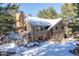 Two-story house with double garage, greenhouse, and snowy landscaping at 746 Bow Mountain Rd, Boulder, CO 80304