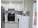 Modern kitchen with white cabinets, stainless steel appliances, and gray tile backsplash at 11638 Community Center Dr # 20, Northglenn, CO 80233