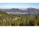 Scenic mountain view with snow-capped peaks and evergreen trees at 11566 Coal Creek Heights Dr, Golden, CO 80403