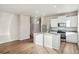 Modern kitchen with white cabinets, stainless steel appliances, and a large island at 3003 Oxley St, Strasburg, CO 80136