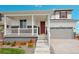 Two-story house with a covered porch, red door, and attached garage at 3292 N Highlands Creek Pkwy, Aurora, CO 80019