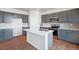 Modern kitchen with grey cabinets, quartz countertops, and stainless steel appliances at 3292 N Highlands Creek Pkwy, Aurora, CO 80019