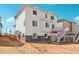 Rear view of two-story home with white siding, deck, and stairs at 3292 N Highlands Creek Pkwy, Aurora, CO 80019