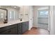 Modern bathroom with double vanity, large mirror, and walk-in closet at 3292 N Highlands Creek Pkwy, Aurora, CO 80019