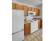 Kitchen with white appliances and wood cabinets at 22975 E Ontario Dr # 101, Aurora, CO 80016