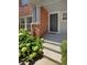 Brick building entrance with dark gray door and landscaping at 22975 E Ontario Dr # 101, Aurora, CO 80016