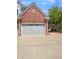 Attached garage with gray door, belonging to a brick home at 22975 E Ontario Dr # 101, Aurora, CO 80016