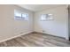 Simple bedroom with hardwood floors and two windows at 1281 Worley Dr, Denver, CO 80221