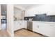 Updated kitchen featuring white cabinets, a subway tile backsplash, and light wood floors at 1133 Race St # 1B, Denver, CO 80206