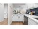 Open concept kitchen boasting white cabinets and a stylish blue tile backsplash at 1133 Race St # 1B, Denver, CO 80206