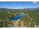 Aerial view of a lake surrounded by trees and mountains at 7142 Lynx Lair Rd, Evergreen, CO 80439