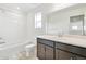 Clean bathroom with tub, toilet, vanity, and dark brown cabinets at 9374 Bahama Ct, Commerce City, CO 80022